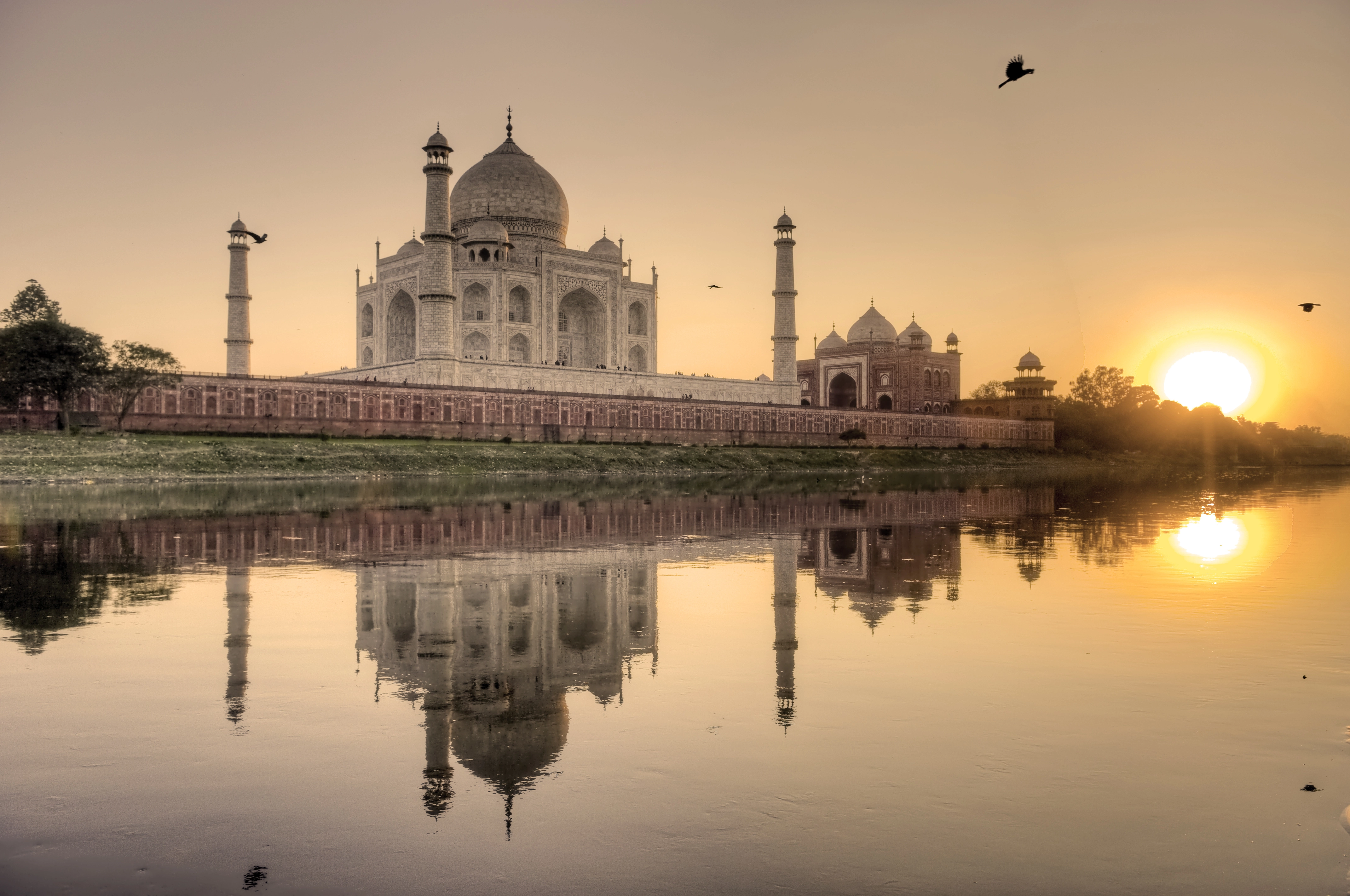 Taj Mahal se reflétant dans l'eau au coucher du soleil
